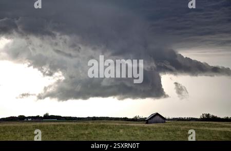 Dark supercell storm clouds gathering over a lonely barn in the countryside Stock Photo
