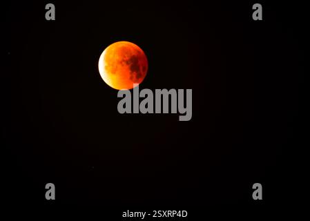 A glowing blood moon during a partial lunar eclipse at night. Stock Photo