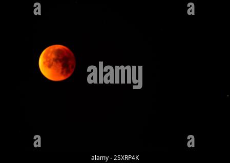 A glowing blood moon during a partial lunar eclipse at night. Stock Photo