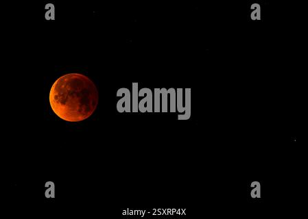 A glowing blood moon during a partial lunar eclipse at night. Stock Photo