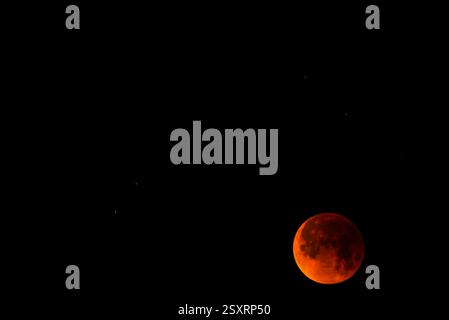 A glowing blood moon during a partial lunar eclipse at night. Stock Photo