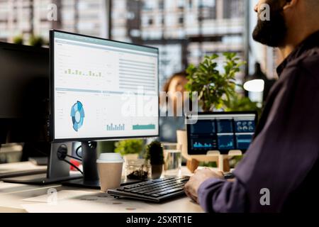 Middle eastern businessman overseeing administrative tasks at desk, reviewing organizational performance metrics for success. Skilled manager analyzing data focused on strategic planning. Stock Photo