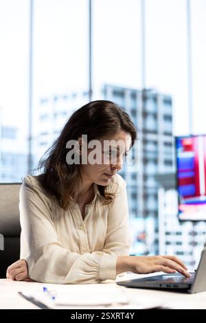 Ambitious focused entrepreneur examines enterprise performance metrics, using data driven analytics and reports to make the right decisions that guarantee efficiency and work ethic. Stock Photo