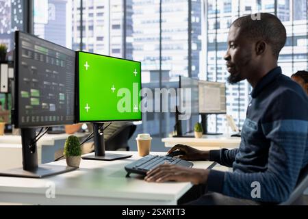 Developer conducting experiments and tests on green screen computer to optimize machine learning models for performance and accuracy. IT expert in office analyzing complex AI data on mockup PC Stock Photo