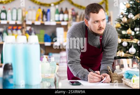 Manager checking financial records in decorated home care shop Stock Photo