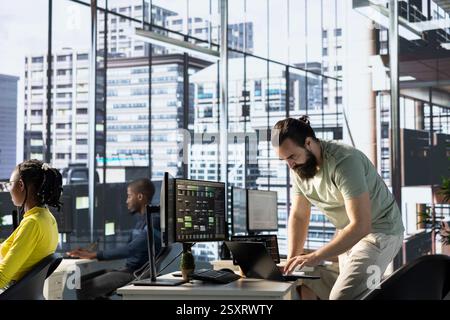 Admin using laptop to manage cloud computing resources and platforms to train and deploy large scale machine learning models. Worker monitoring and maintaining company systems using notebook Stock Photo
