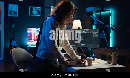 Developer holding disposable cup of coffee entering office to implement security measures, protecting company systems and data. IT worker starting job shift, testing and debugging code, camera B Stock Photo