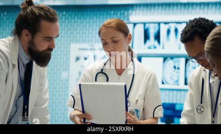 Medical staff collaborates on diagnostic procedures and treatment plans. Radiology specialists work on accurate diagnosis and effective disease prevention, healthcare industry insurance. Camera A. Stock Photo