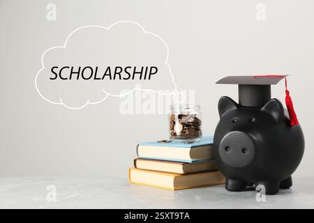 Scholarship. Piggy bank, graduate hat, books and coins on light grey table. Speech cloud with word coming out jar Stock Photo
