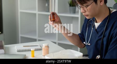 Medical student focused on medication management while studying in a modern workspace. Stock Photo