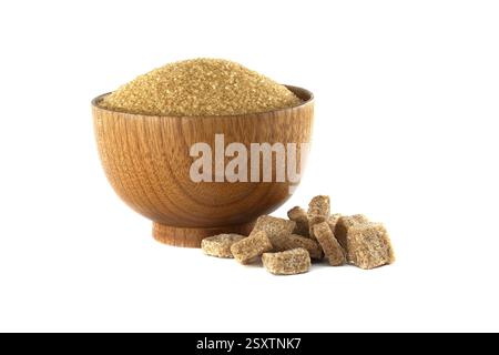 Wooden bowl filled with brown sugar alongside a small pile of brown sugar cubes, isolated on a white background. Stock Photo