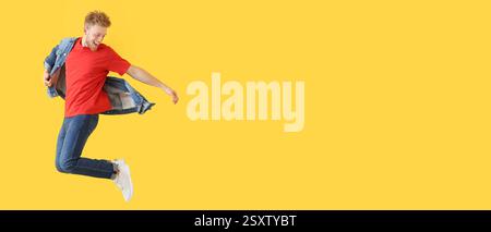 Jumping young man in denim clothes on yellow background with space for text Stock Photo
