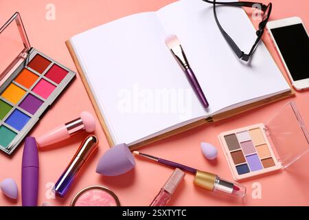 Composition with makeup cosmetics, modern mobile phone, eyeglasses and notebook on coral background Stock Photo