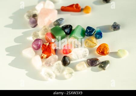 View of various colorful semi-precious polished stones on a white table Stock Photo