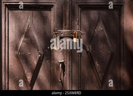 close-up of an old wooden door locked with a metal padlock Stock Photo