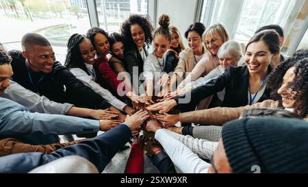 Successful team working together displaying unity and collaboration in an office environment with diverse backgrounds. Stock Photo