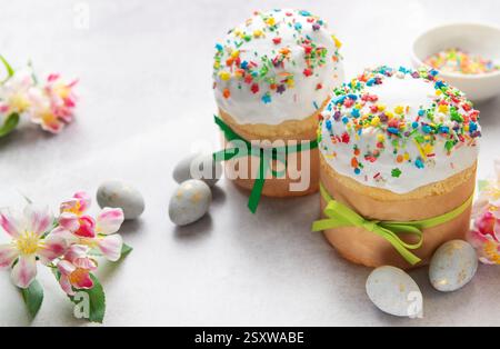Traditional easter cakes decorated with colorful sprinkles and accompanied by painted eggs, celebrating the arrival of spring Stock Photo