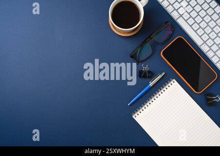 Blank touchscreen smartphone and keyboard on dark blue desk Stock Photo