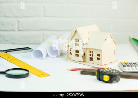 small house blueprints and drawing tools on brick wall background Stock Photo