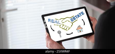 Real estate concept shown on a tablet held by a man Stock Photo