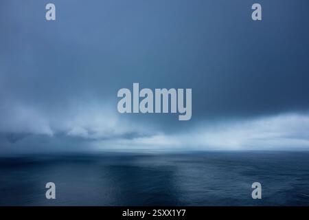 Dramatic Cloudy Sky Over Calm Ocean Water in a Serene Landscape Stock Photo