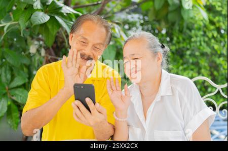 Senior use phone having fun and enjoying looking at screen for video call to family. Leisure and free time concept Stock Photo
