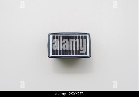 Small solar panel installed on wall at home for use lighting in night time. Electricity saving cost concept. Stock Photo