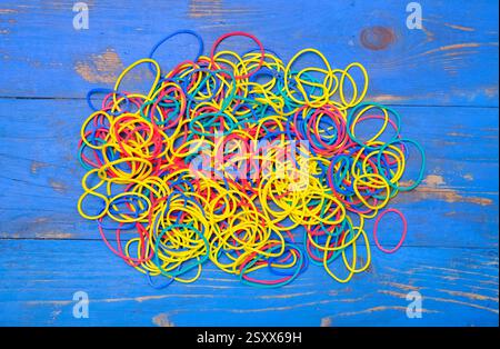 selection of colourful elastic bands on blue painted background Stock Photo