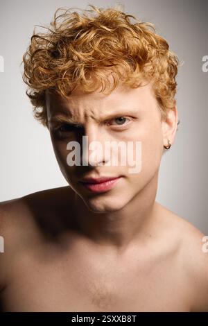 Young man with curly blonde hair poses confidently, embodying modern fashion and charm. Stock Photo