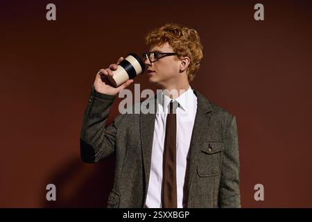 A stylish young man sips coffee, exuding confidence in a chic setting. Stock Photo