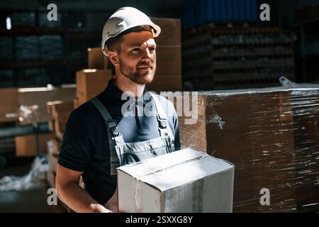 Employee in uniform is working in the storage at daytime. Stock Photo