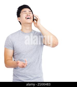 Laughing Asian man talking on smartphone, having fun conversation at home Stock Photo