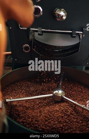 Vertical shot of coffee beans being roasted by professional roaster machine at factory Stock Photo
