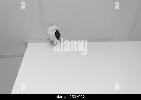 Surveillance Camera Strategically Mounted on Ceiling in a Clean, Minimalist Setting and Design Stock Photo