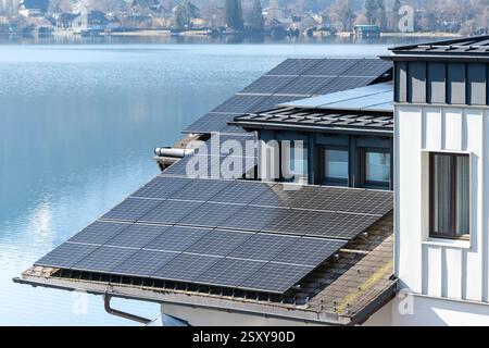 Alternative energy: solar panels on the roof of a country house by the lake Stock Photo