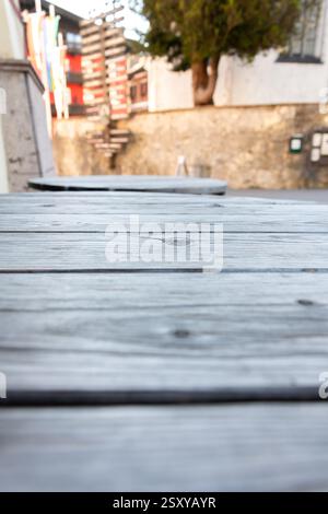 Aged wood texture in street interior - close-up of grey wooden boards on a table with blurred background, copy space Stock Photo