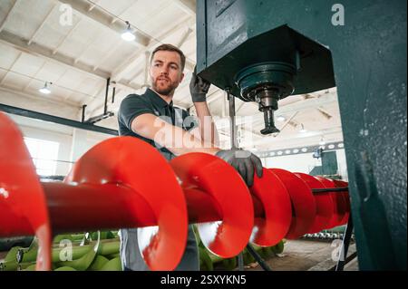 Professional engineer operating machine. Man in uniform is in workstation developing details of agriculture technique. Stock Photo