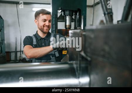 Professional engineer operating machine. Man in uniform is in workstation developing details of agriculture technique. Stock Photo