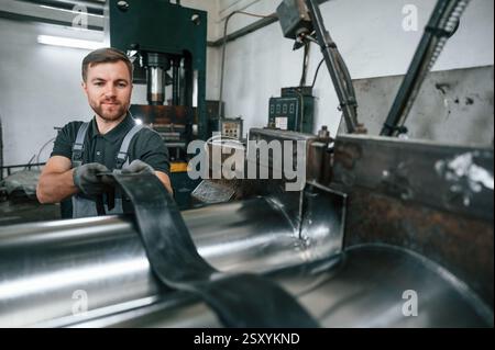 Professional engineer operating machine. Man in uniform is in workstation developing details of agriculture technique. Stock Photo