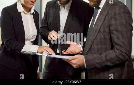 Group of diverse employees holding clipboard for daily planning documents in clipboard, colleagues  Stock Photo