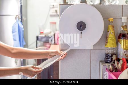 The maid was pulling the tissue paper by hand for cleaning. Stock Photo