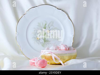 Beautiful plate and pink easter eggs on white background Stock Photo