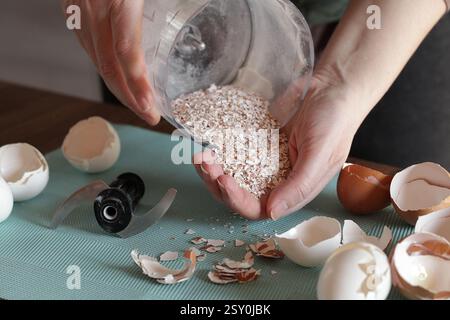 Preparing Eggshell Powder. Woman grinds eggshells with blender. Calcium supplement, cracked eggshell, natural compost ingredient, broken eggshell Stock Photo