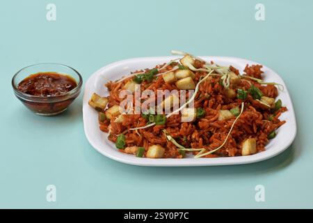 Schezwan paneer fried rice with schezwan sauce, Chinese fried rice with paneer, garnished with spring onion and cabbage Stock Photo