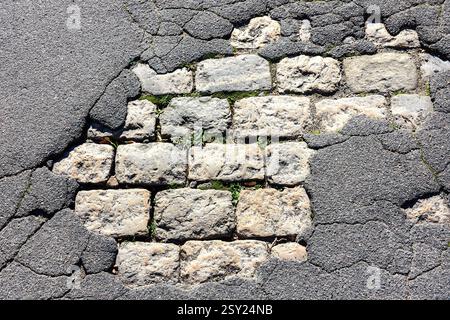 Broken road surface revealing old stone setts - Tours, Indre-et-Loire (37), France. Stock Photo