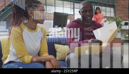 Discussing documents, colleagues in office with data processing image over them Stock Photo
