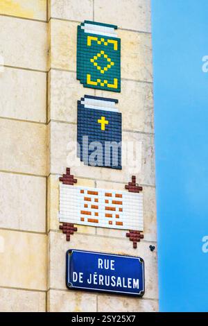 Mosaic tiled street art by "Invader" (aka. Franck Slama) on religious theme - Tours, Indre-et-Loire (37), France. Stock Photo