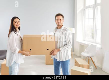 Moving boxes, smiling family new living room entering, couple enjoys new home, first flat owners Stock Photo