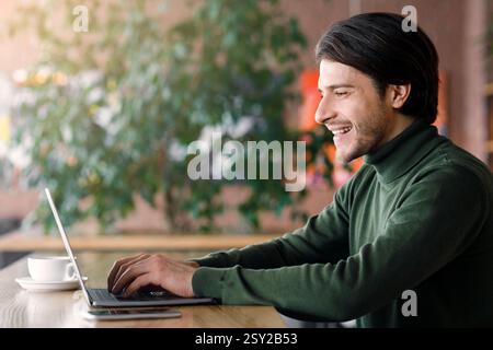 Successful web-designer working at cafe, using laptop Stock Photo