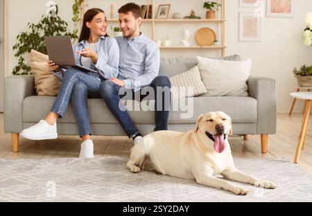 Young couple at home with a tablet and labrador Stock Photo